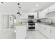 Kitchen with stainless steel appliances, stylish pendants, and granite countertops at 7110 Bonito St, Tampa, FL 33617