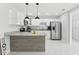Open kitchen view with island, stainless appliances, and marble floor at 7110 Bonito St, Tampa, FL 33617