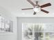 Bright living room featuring a ceiling fan, large windows, and fresh white paint at 7110 Bonito St, Tampa, FL 33617