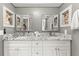 Elegant bathroom featuring dual sinks, granite countertops, framed mirrors, and stylish fixtures at 8103 Bardmoor Pl # 203G, Seminole, FL 33777