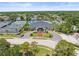 Aerial view of clubhouse and surrounding landscape, featuring tennis courts and lush greenery at 8103 Bardmoor Pl # 203G, Seminole, FL 33777