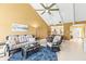 Inviting living room featuring a vaulted ceiling, tile floors, and seamless flow to the kitchen at 8103 Bardmoor Pl # 203G, Seminole, FL 33777