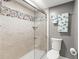 Modern bathroom with a glass-enclosed shower adorned with stylish pebble accents and neutral tile at 8103 Bardmoor Pl # 203G, Seminole, FL 33777