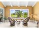 Relaxing sun room with golf course views, tile flooring, and comfortable seating at 8103 Bardmoor Pl # 203G, Seminole, FL 33777