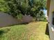 A grassy backyard lined with a privacy wall and blooming shrubs at 9200 Halberg Dr, Hudson, FL 34669