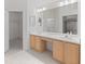 Bathroom with a dual sink vanity, ample storage, and a large mirror at 9200 Halberg Dr, Hudson, FL 34669
