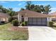 Inviting single-story home with manicured landscaping and a spacious driveway leading to the two-car garage at 9200 Halberg Dr, Hudson, FL 34669