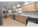Spacious kitchen featuring light wood cabinets, stainless steel dishwasher, and tile flooring at 9200 Halberg Dr, Hudson, FL 34669