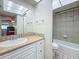 Bright bathroom featuring a vanity with sink and mirror, adjacent to a tiled shower and tub combination at 1 Boca Ciega Point Blvd # 215, St Petersburg, FL 33708