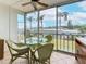The lanai has comfortable seating, a glass-top table, and a picturesque view of palm trees at 1 Boca Ciega Point Blvd # 215, St Petersburg, FL 33708