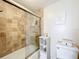 Bathroom with a shower-tub combo featuring tiled walls and a glass door at 100 Pierce St # 910, Clearwater, FL 33756