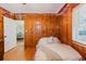Bedroom featuring wood paneled walls, hardwood floors and string lights at 103 N Meteor Ave, Clearwater, FL 33765