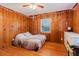 Bedroom featuring wood paneled walls, hardwood floors and string lights at 103 N Meteor Ave, Clearwater, FL 33765