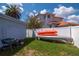 Private backyard features a white fence, lush green grass, and ample space for outdoor activities and kayak storage at 111 Chesapeake Ave, Tampa, FL 33606