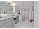 Bathroom with dual sinks, gray cabinets, a glass shower, and tub at 111 Chesapeake Ave, Tampa, FL 33606