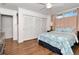 Cozy bedroom with light-colored walls, wood floors, and three white closet doors at 111 Chesapeake Ave, Tampa, FL 33606