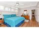 Bright bedroom featuring shutters, a ceiling fan, wood floors, and blue bedding at 111 Chesapeake Ave, Tampa, FL 33606