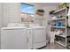 Bright laundry room features a washer and dryer, along with shelves for storage and a window for natural light at 111 Chesapeake Ave, Tampa, FL 33606