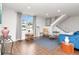 Bright living room featuring stylish decor, wood flooring, a large window with curtains, and a staircase at 111 Chesapeake Ave, Tampa, FL 33606