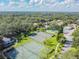 An aerial view of community tennis courts and a pool surrounded by trees at 11764 Raintree Dr # 0, Temple Terrace, FL 33617
