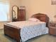 This bedroom features wood furniture, window with curtain, and patterned grey and white comforter at 11764 Raintree Dr # 0, Temple Terrace, FL 33617