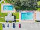 Aerial view of two community pools with lounge chairs and a parking lot at 11764 Raintree Dr # 0, Temple Terrace, FL 33617