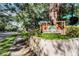 Community sign for Raintree Manor surrounded by mature trees and lush landscaping at 11764 Raintree Dr # 0, Temple Terrace, FL 33617