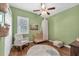 Bedroom room with green walls, wood floors, a rocking chair, and a crib with a canopy at 11808 Holly Crest Ln, Riverview, FL 33569