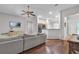 Open living room with wood flooring, a ceiling fan, and a view of the kitchen and front entrance at 11808 Holly Crest Ln, Riverview, FL 33569