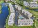 Aerial view of condo community with lush landscaping, a pool, parking, and access to golf course and waterways at 1200 Country Club Dr # 6302, Largo, FL 33771