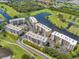 Aerial of condo buildings near a river with a golf course and parking, surrounded by trees at 1200 Country Club Dr # 6302, Largo, FL 33771