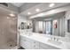 Bathroom with double sinks, glass-enclosed shower, large mirror, and ample counter space at 1200 Country Club Dr # 6302, Largo, FL 33771