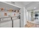 Laundry closet featuring a washer, dryer, storage shelf, and a white door at 1200 Country Club Dr # 6302, Largo, FL 33771