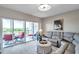 Bright living room with a comfortable gray sofa, access to a balcony, and picturesque views of the surrounding landscape at 1200 Country Club Dr # 6302, Largo, FL 33771