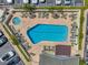 Aerial view of a resort-style pool with lounge chairs, tables, and lush landscaping at 1200 Country Club Dr # 6302, Largo, FL 33771