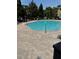 Community pool with brick paver deck and lounge chairs surrounded by trees at 12631 Silverdale St, Tampa, FL 33626