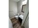 Modern half bathroom featuring hardwood floors, vanity sink, and toilet at 12631 Silverdale St, Tampa, FL 33626