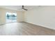 Large bedroom with sliding glass door and ceiling fan above wood-look flooring at 12910 Longcrest Dr, Riverview, FL 33579