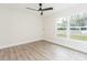 Bright bedroom features wood-look flooring, ceiling fan, and window views at 12910 Longcrest Dr, Riverview, FL 33579