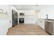 A modern kitchen with white cabinetry, stainless steel appliances, and a view into an adjacent living space at 12910 Longcrest Dr, Riverview, FL 33579