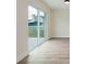 View of patio through sliding glass door with neutral walls and wood-look flooring at 12910 Longcrest Dr, Riverview, FL 33579