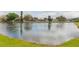 Scenic view of a tranquil pond surrounded by lush greenery and houses in the background at 12910 Longcrest Dr, Riverview, FL 33579