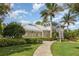 A clubhouse with a metal roof is surrounded by a lush landscape that welcomes residents at 13421 Lake Monroe Pl, Riverview, FL 33579