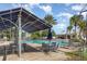 Community pool is shaded by a modern pergola and palm trees, with tables and loungers for relaxing at 13421 Lake Monroe Pl, Riverview, FL 33579