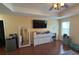 Bright main bedroom featuring wood floors, a large dresser, and tray ceilings at 13421 Lake Monroe Pl, Riverview, FL 33579