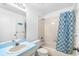 Clean bathroom featuring white tiled tub and shower with decorative blue and white curtain at 13437 Beechberry Dr, Riverview, FL 33579