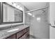 Bathroom with gray granite counter, framed vanity mirror, and glass enclosed shower at 13437 Beechberry Dr, Riverview, FL 33579