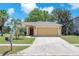 Charming single-story home featuring a two-car garage, well-maintained lawn, and tropical landscaping at 13437 Beechberry Dr, Riverview, FL 33579