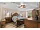 Bright bedroom featuring tray ceiling, hardwood floors, wooden furniture set, and serene decor at 13598 Park Blvd, Seminole, FL 33776