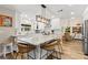 Bright kitchen boasts granite counters, white cabinets, stainless appliances, and a large island with seating at 13598 Park Blvd, Seminole, FL 33776